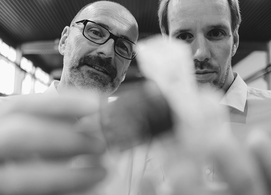 Black & white photo of two Hammerforce engineers working on a part