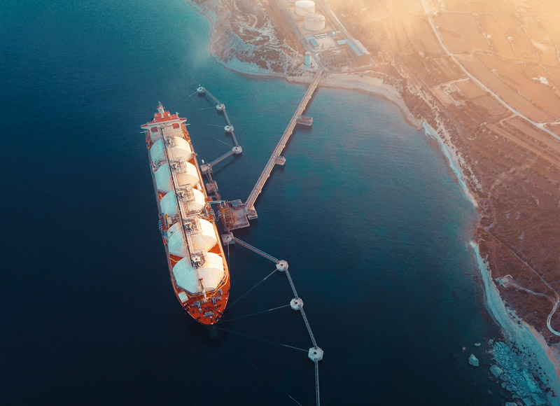 Aerial photo of a LNG boat docking at a seaside port